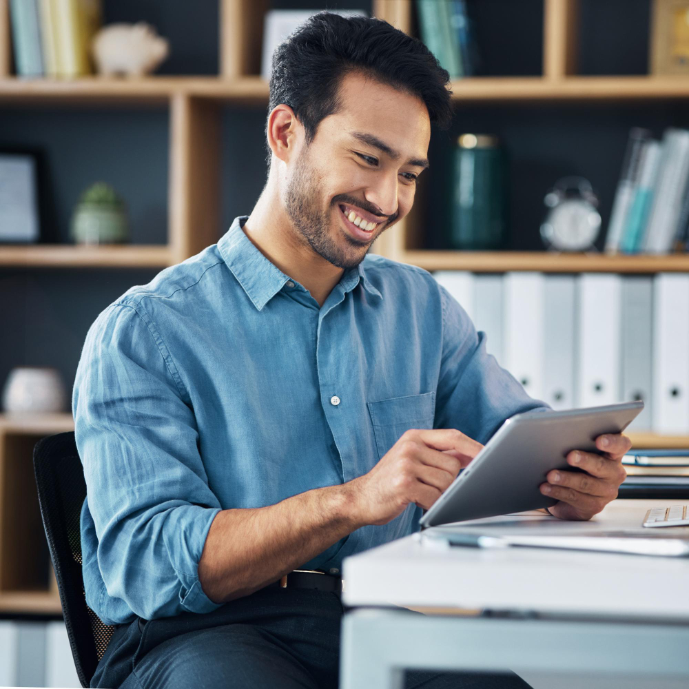 happy-asian-man-tablet-smile-social-media-communication-networking-office-desk